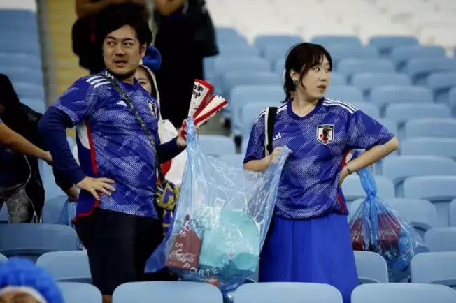 Suporter Timnas Jepang melakukan aksi bersih-bersih sampah di stadion. (Foto : reuters)