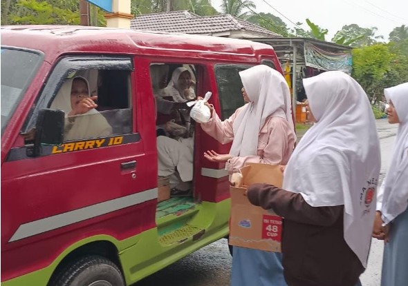 Para Siswi SMAN 1 Lampihong membagikan makanan kepada jemaah Guru Bakhiet. (Foto : Istimewa)