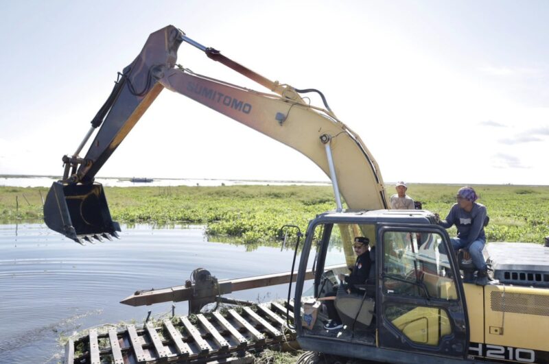Ketua DPRD Kalsel saat menggunakan alat berat untuk membersihkan enceng gondok yang menutupi transportasi sungai.(Foto : Istimewa)