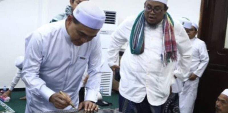Bupati Kabupaten Tanah Bumbu, Zairullah Azhar, menandatangani prasasti tanda selesainya renovasi pembangunan infrastruktur makam bersejarah. (Foto : Istimewa)