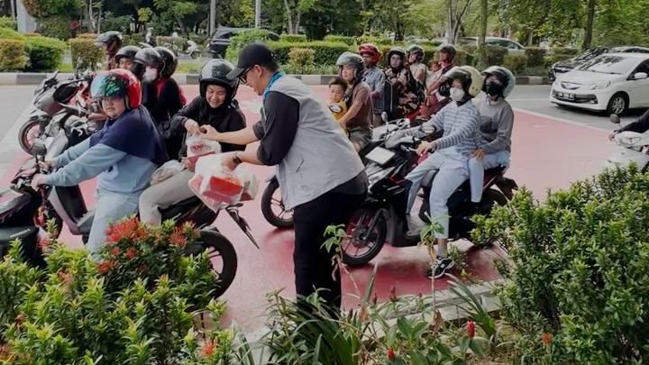 Salah seorang pegawai PLN UP2B Kalimantan Barat sedang membagikan takjil kepada warga yang melintas di Jl. A. Yani Pontianak