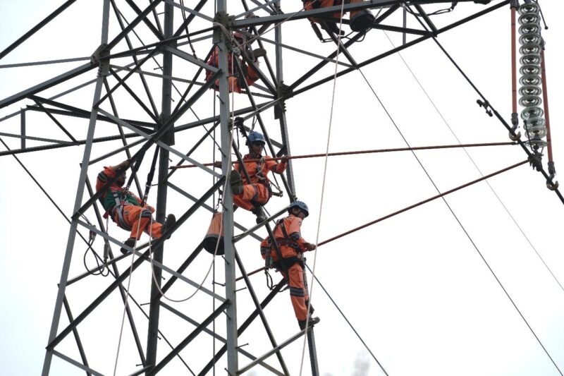 Ilustrasi pekerjaan perbaikan tower di ketinggian oleh tim pemeliharaan PT PLN (Persero)