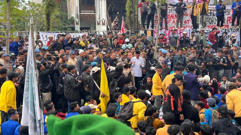 Supian HK mengenakan baju kameja putih dengan songkok hitam didampingi sejumlah anggota DPRD Kalsel dan dikawal ketat oleh apparat kepolisian. (Foto : wasaka.id)