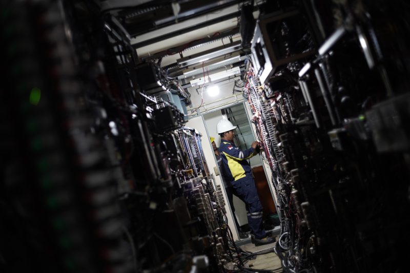 Petugas PLN tengah melakukan pemeriksaan dan penyambungan instalasi proteksi di ruang panel Gardu Induk. Pekerjaan modernisasi peralatan dilakukan untuk memperkuat keandalan sistem kelistrikan dalam rangka menyambut Hari Pahlawan.