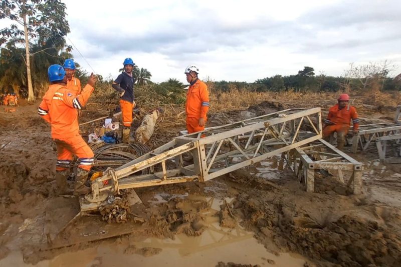 Di tengah medan yang berlumpur, petugas PLN melakukan perakitan tower darurat di jalur transmisi Langsa-Pangkalan Brandan.