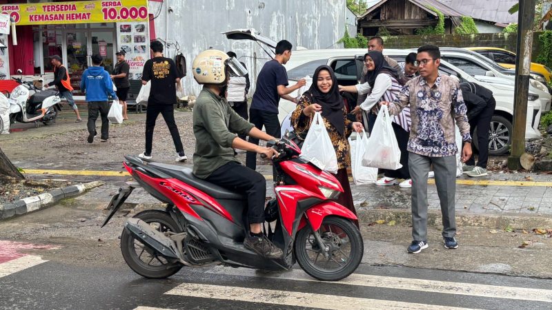 Momen dimana Karyawan UPT Banjarbaru memberikan Takjil kepada pengendara sepeda motor yang melintas di kawasan Panglima Batur, Banjarbaru.