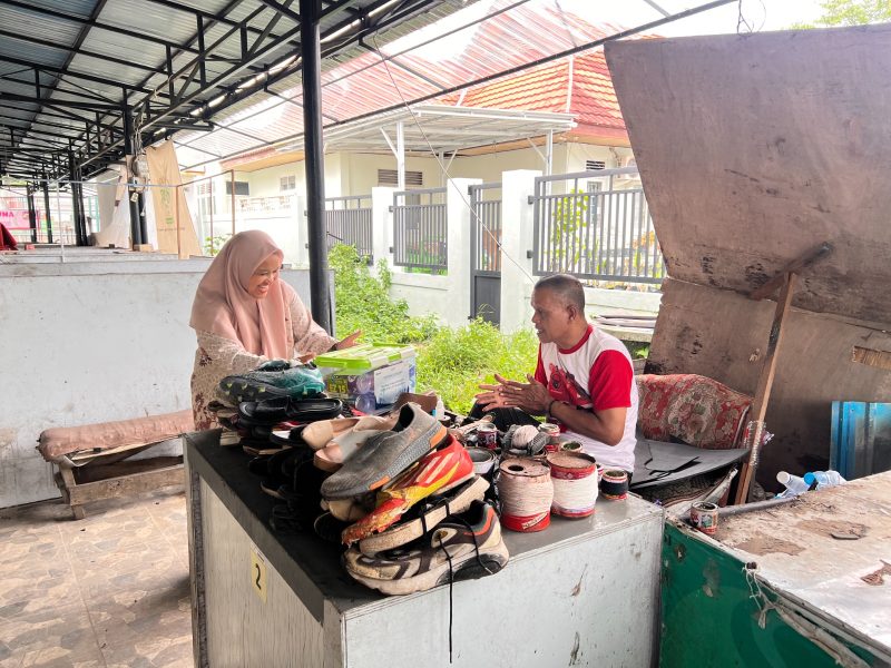 Salah satu srikandi PLN menyerahkan paket sembako Ramadan kepada tukang sol sepatu sebagai bentuk kepedulian kepada para pekerja informal yang tetap berjuang mencari nafkah di jalanan.