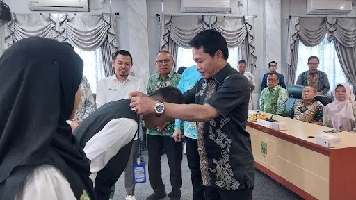 Bupati Balangan, Abdul Hadi menyematkan tanda kepada peserta program kerja ke Jepang. (Foto: Istimewa)