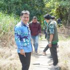 Anggota DPRD Kabupaten Balangan, Fatturahman melihat langsung kondisi jembatan kayu yang sudah rusak dan membahayakan warga yang melintas. (Foto: Istimewa)